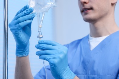 Photo of Nurse setting up IV drip in hospital, closeup