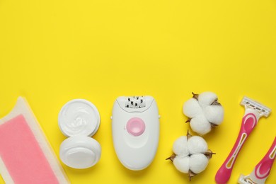 Photo of Different epilation products and fluffy cotton flowers on yellow background, flat lay. Space for text