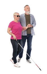 Mature man helping blind person with long cane on white background