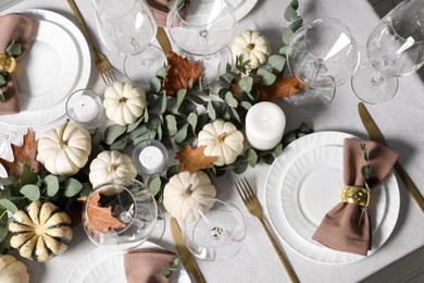 Photo of Beautiful autumn table setting. Plates, cutlery, glasses, pumpkins and floral decor, flat lay