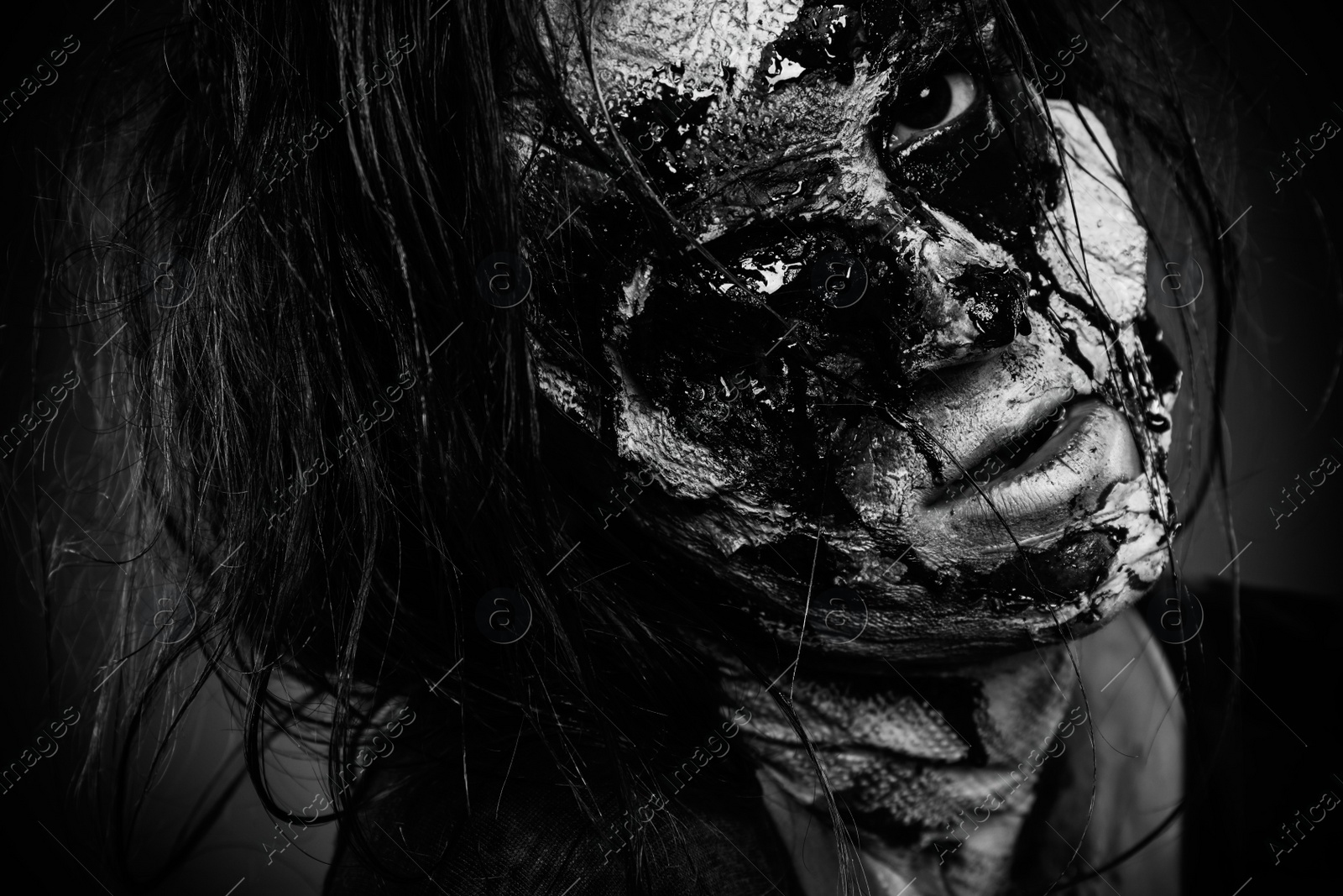 Photo of Scary zombie on dark background, black and white effect. Halloween monster