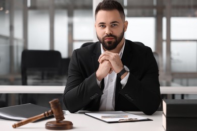 Photo of Portrait of serious lawyer at table in office