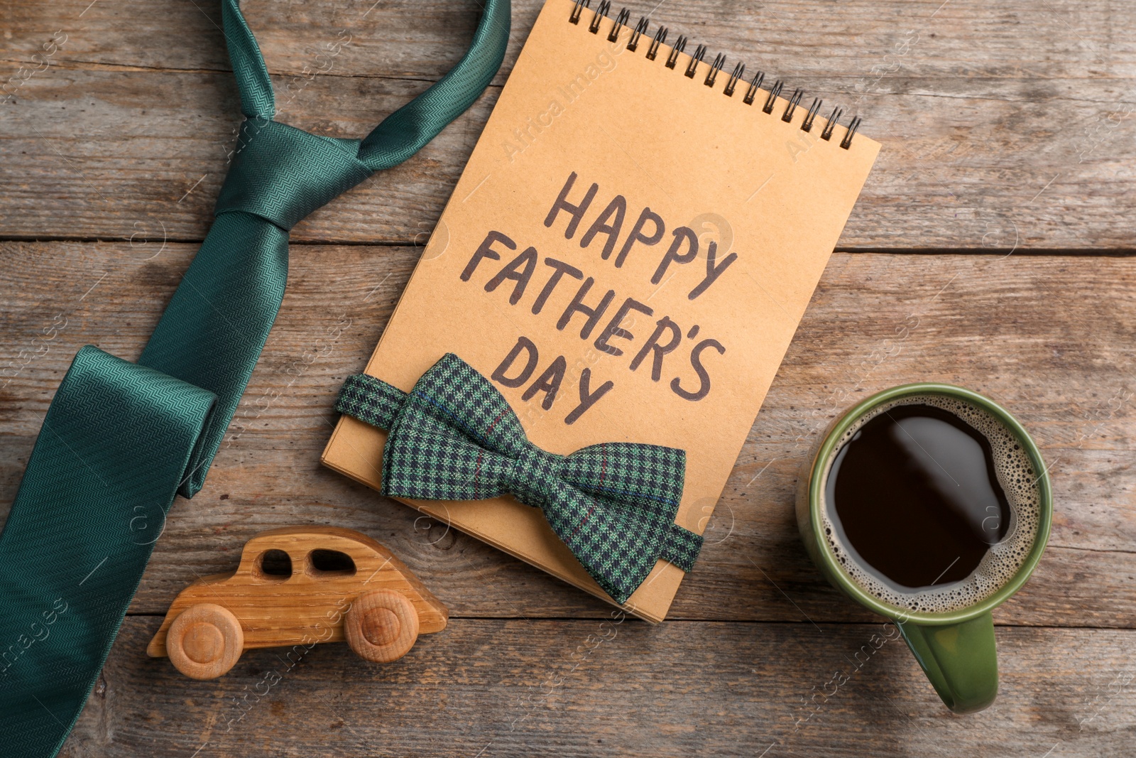 Photo of Flat lay composition with notebook, cup of coffee and accessories on wooden background. Father's day celebration