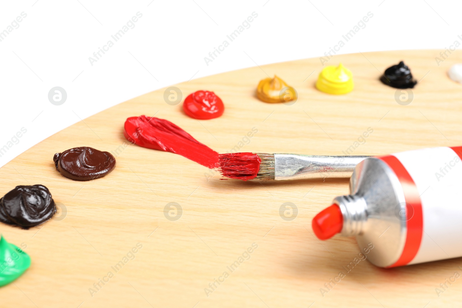 Photo of Palette with acrylic paints and brush on white background, closeup. Artist equipment