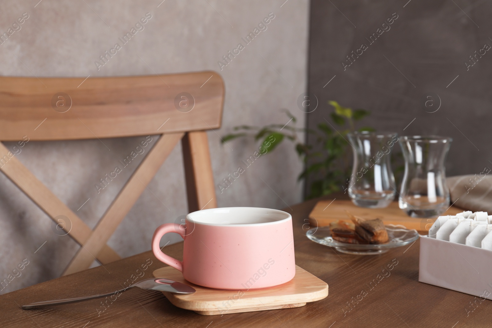 Photo of Cup of hot tea and bags on table. Space for text