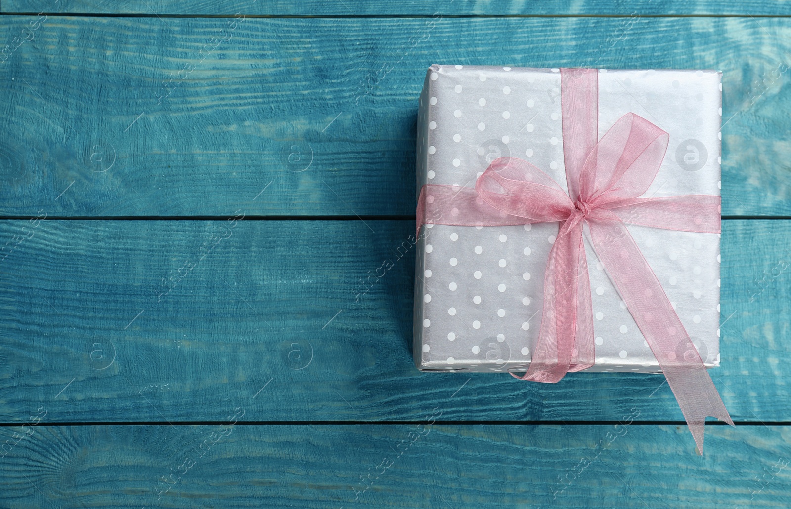 Photo of Elegant gift box with bow on wooden background, top view