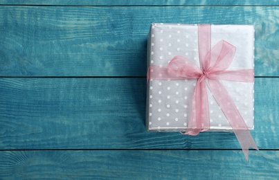 Elegant gift box with bow on wooden background, top view