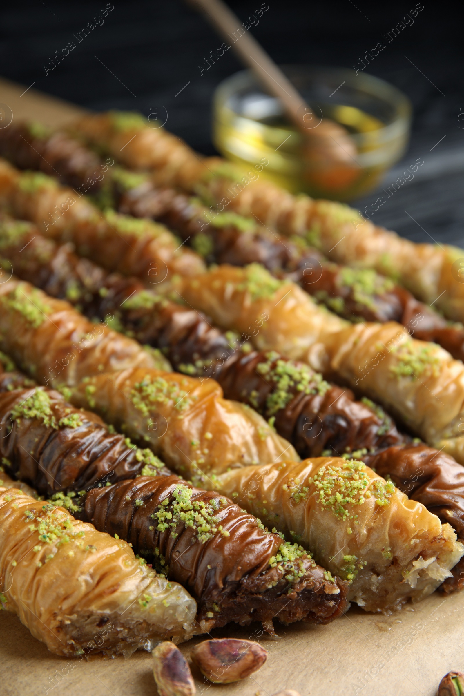 Photo of Delicious sweet baklava with pistachios on parchment paper, closeup