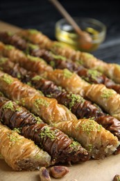 Delicious sweet baklava with pistachios on parchment paper, closeup