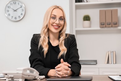 Photo of Happy secretary in glasses at table in office
