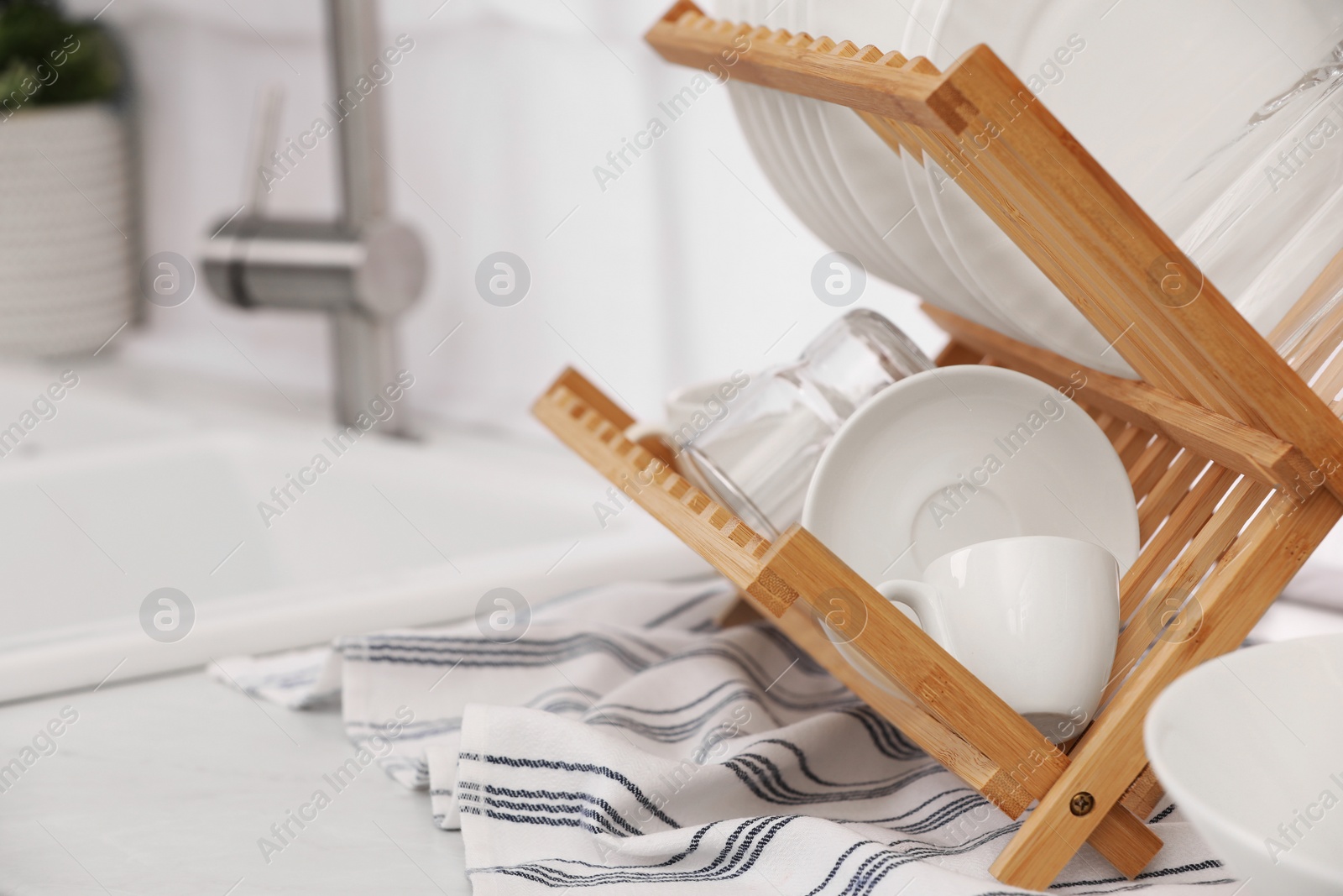 Photo of Drying rack with clean dishes on countertop in kitchen. Space for text