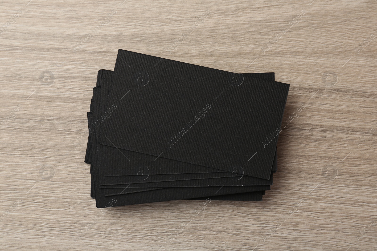 Photo of Blank black business cards on wooden table, top view. Mockup for design