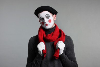 Portrait of mime artist in beret on grey background