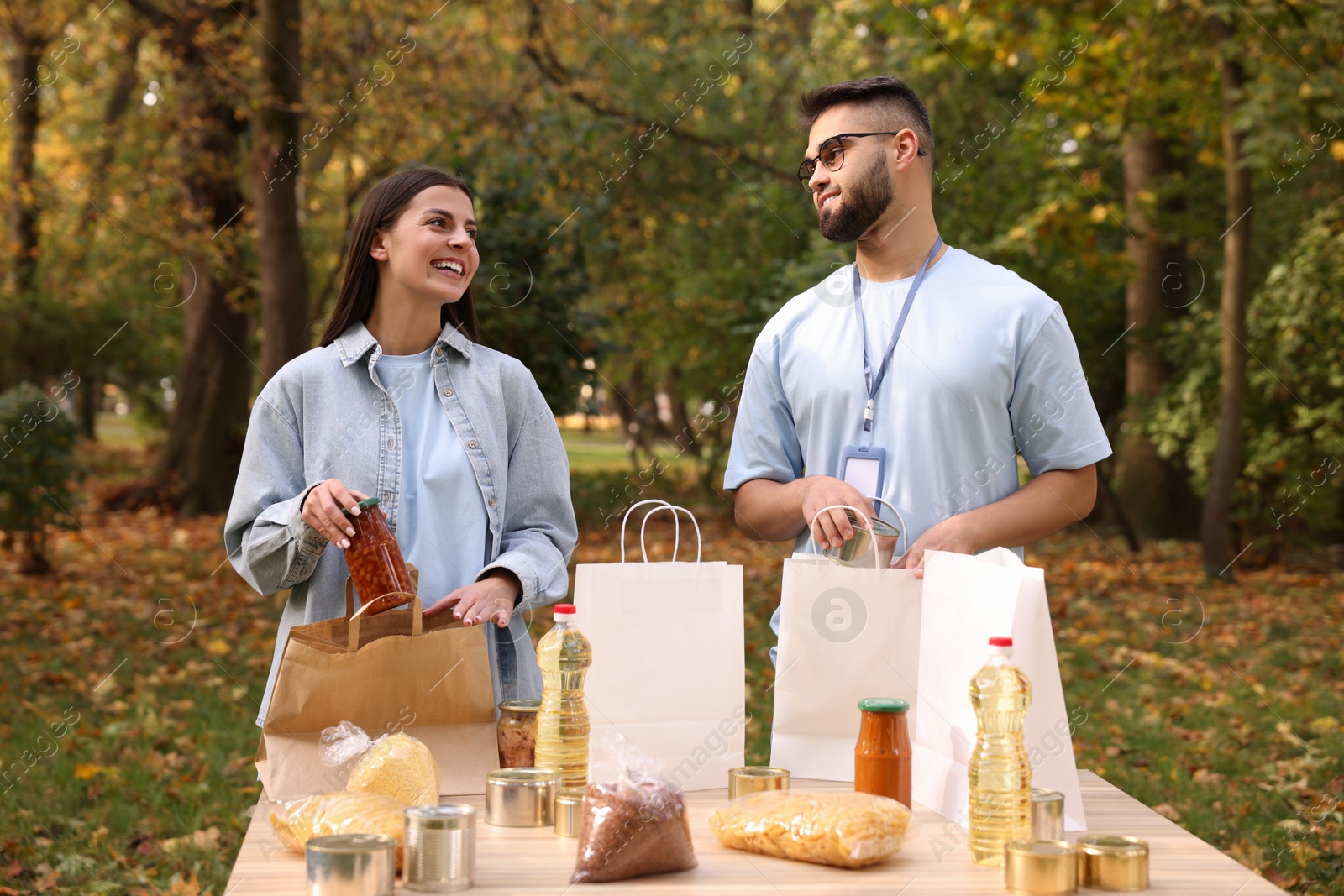 Photo of Volunteers packing food products at table in park