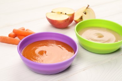 Photo of Baby food. Purees of apples and carrots in bowls on white wooden table