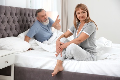 Mature couple with problem in relationship on bed at home