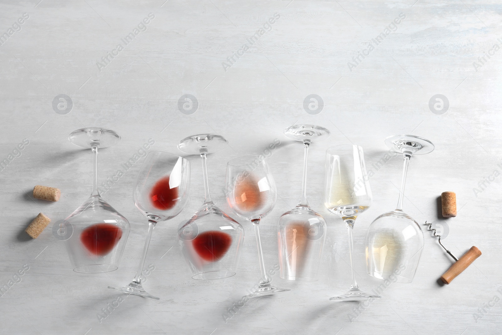 Photo of Different glasses with wine on light background, flat lay