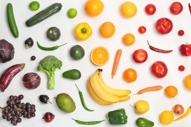 Rainbow composition with fresh vegetables and fruits on white background, flat lay