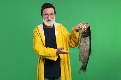 Photo of Fisherman with caught fish on green background