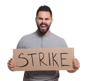 Angry young man holding cardboard banner with word Strike on white background