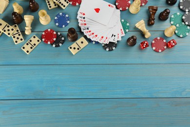 Elements of different board games on light blue wooden table, flat lay. Space for text