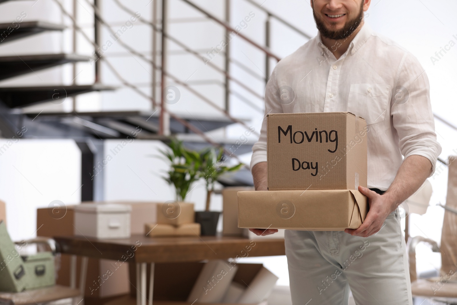 Photo of Man holding moving boxes in new office, closeup. Space for text