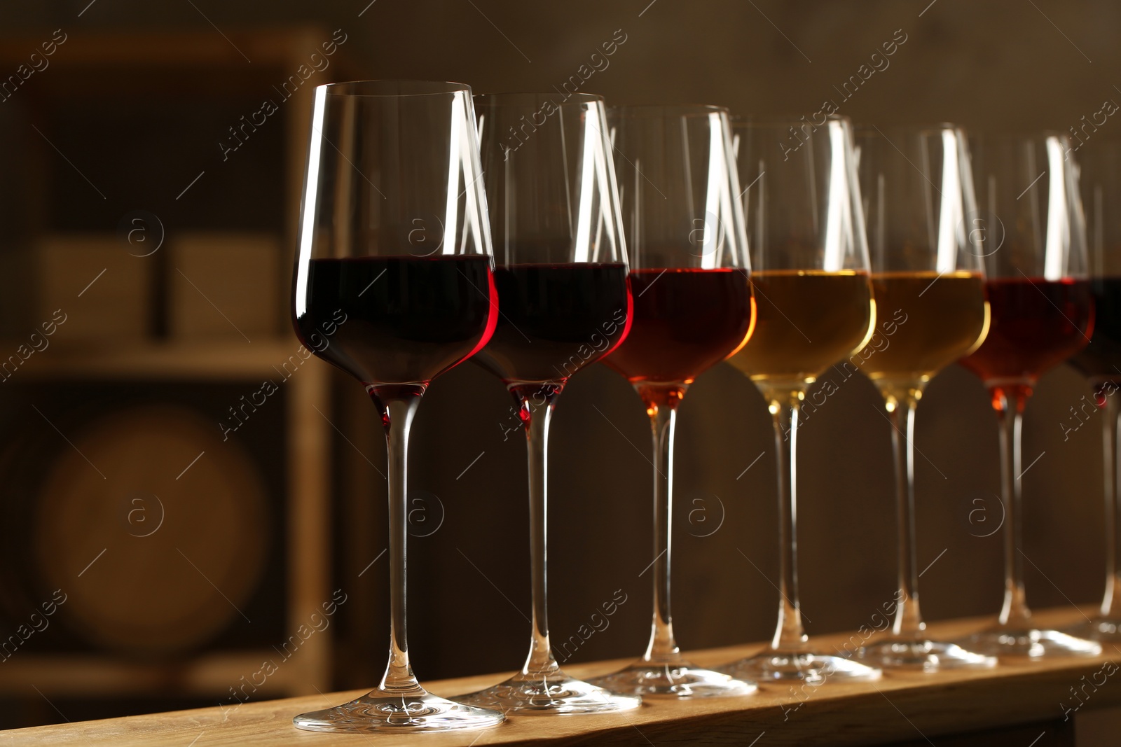 Photo of Glasses of different wines in cellar. Expensive collection