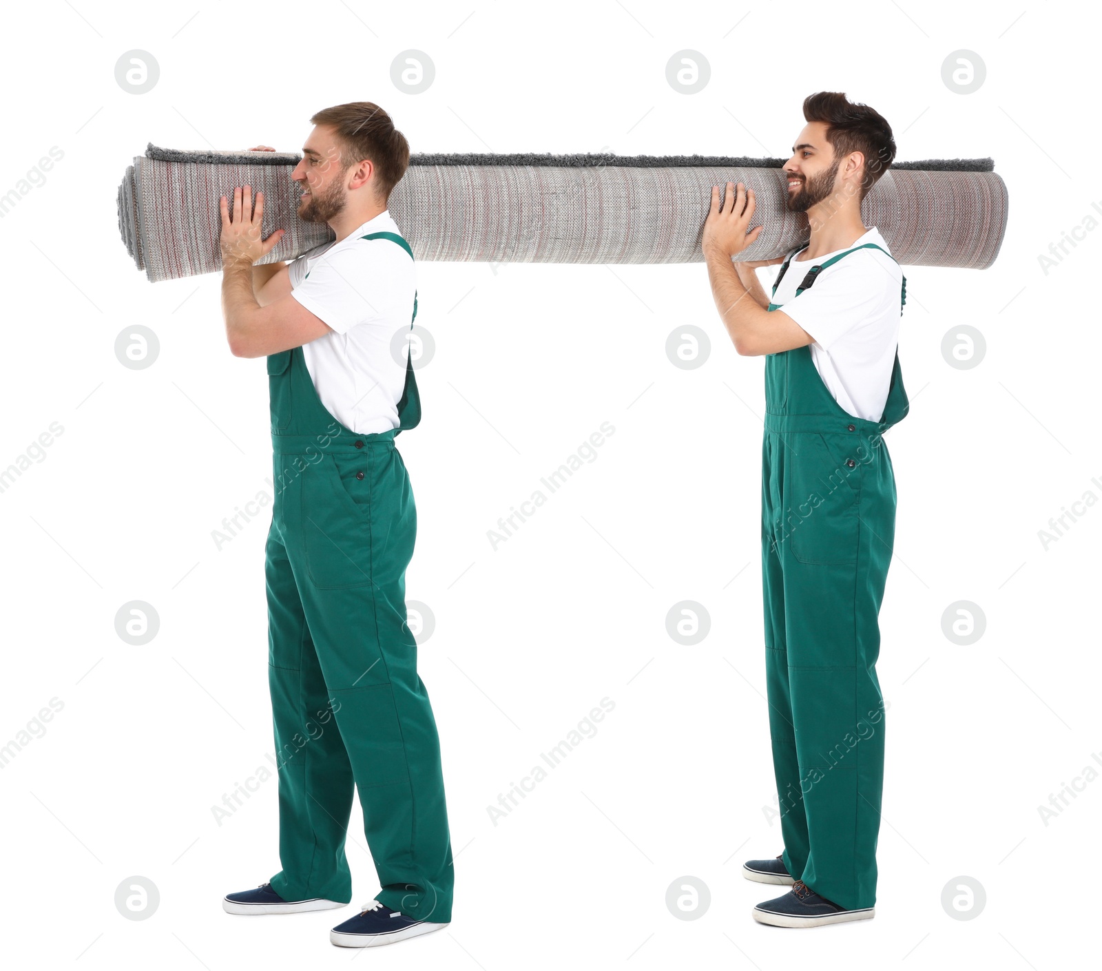 Photo of Young workers carrying rolled carpet isolated on white. Moving service