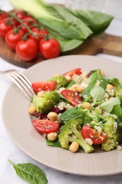 Photo of Healthy meal. Tasty salad with quinoa, chickpeas and vegetables served on table, closeup