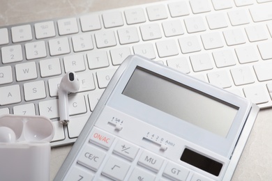 Calculator, earphones and keyboard on light table, closeup. Tax accounting