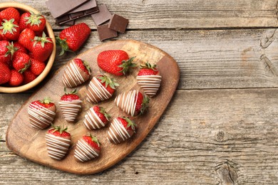 Photo of Delicious chocolate covered strawberries on wooden table, flat lay. Space for text