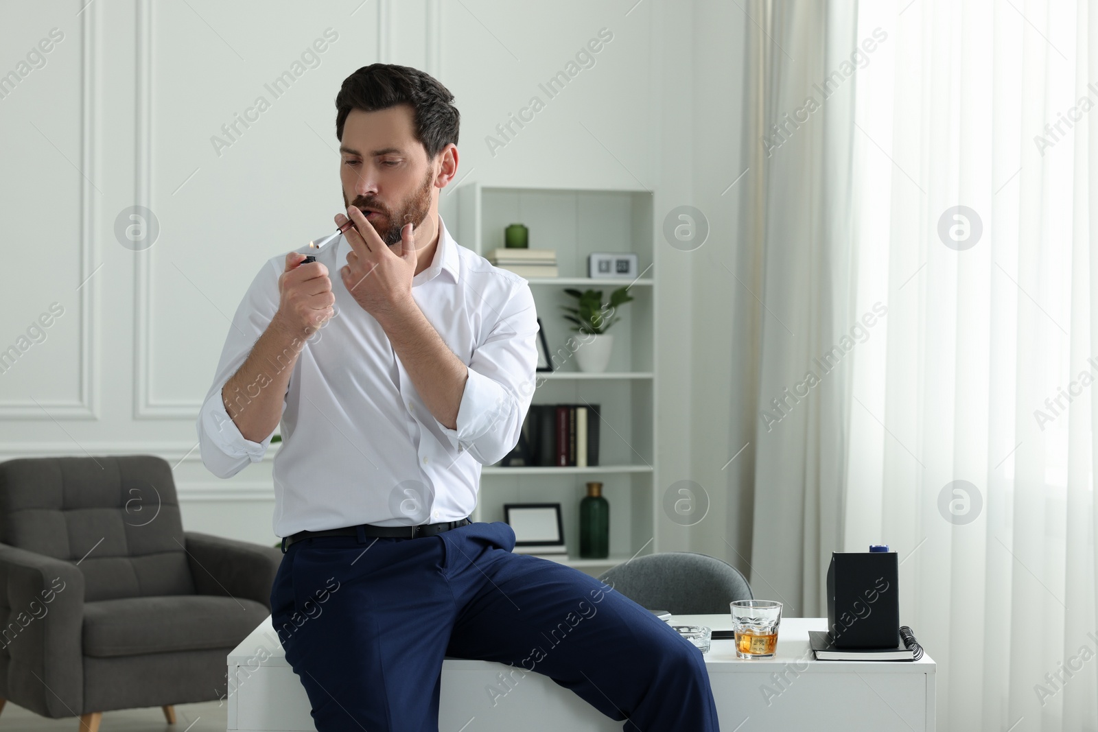 Photo of Man using cigarette holder for smoking in office
