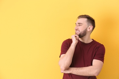 Portrait of smiling young man on color background