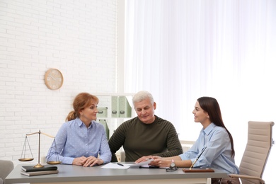 Young lawyer consulting senior couple in office