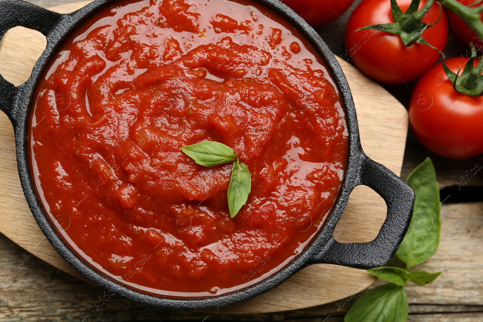 Photo of Homemade tomato sauce in bowl and fresh ingredients on table, flat lay