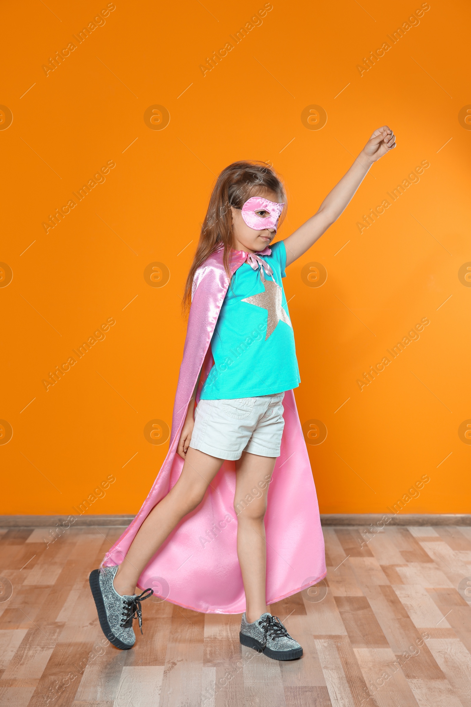 Photo of Adorable little child playing superhero indoors