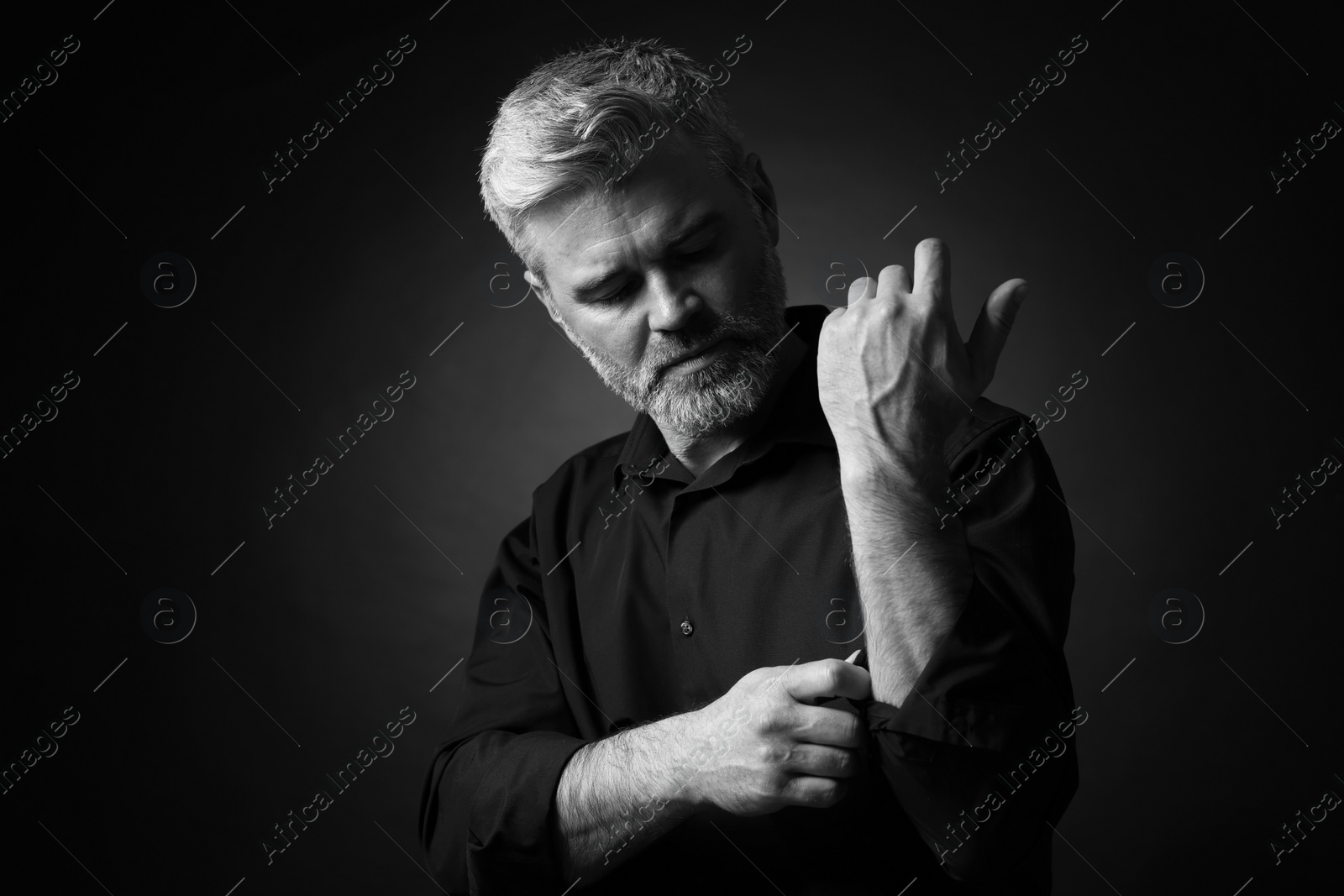 Photo of Portrait of handsome man on dark background. Black and white effect