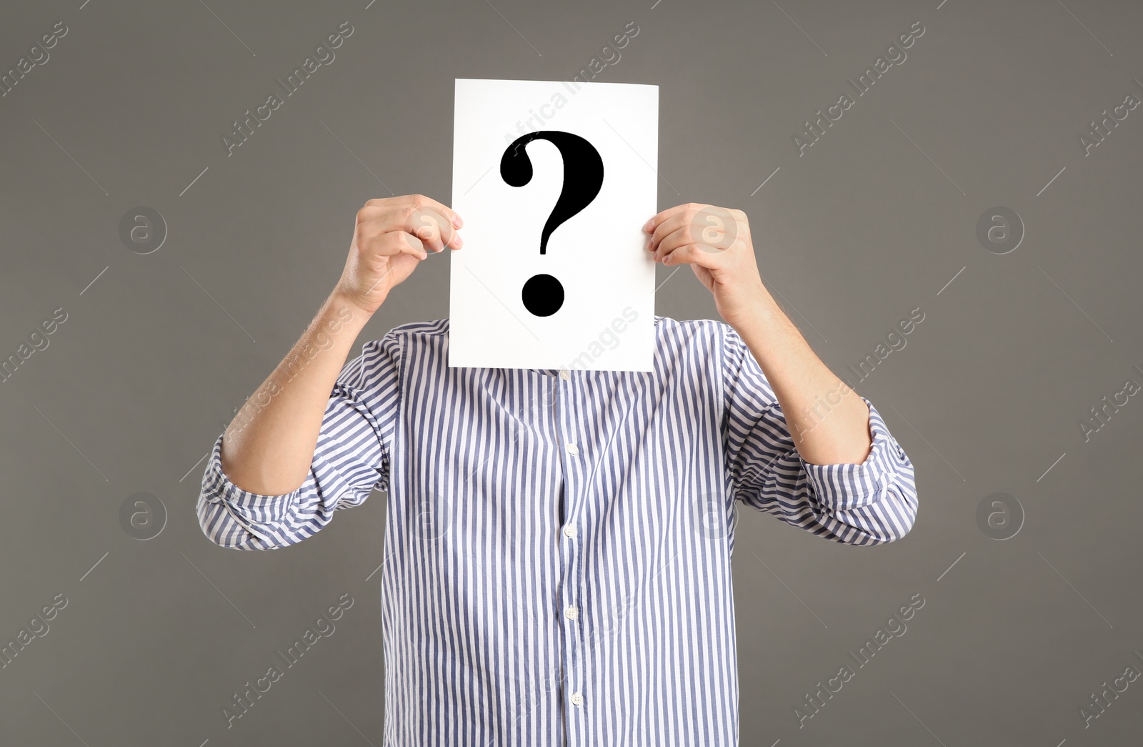 Photo of Man holding paper with question mark on grey background