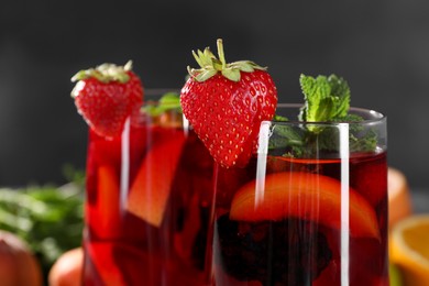 Photo of Glasses of delicious refreshing sangria on blurred background, closeup view