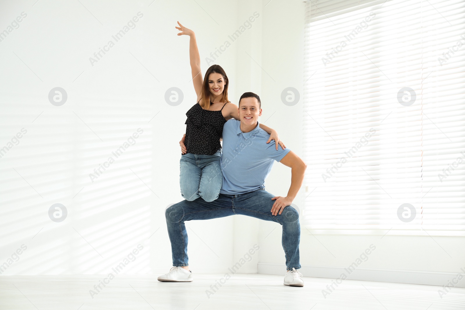 Photo of Happy young couple dancing in empty studio