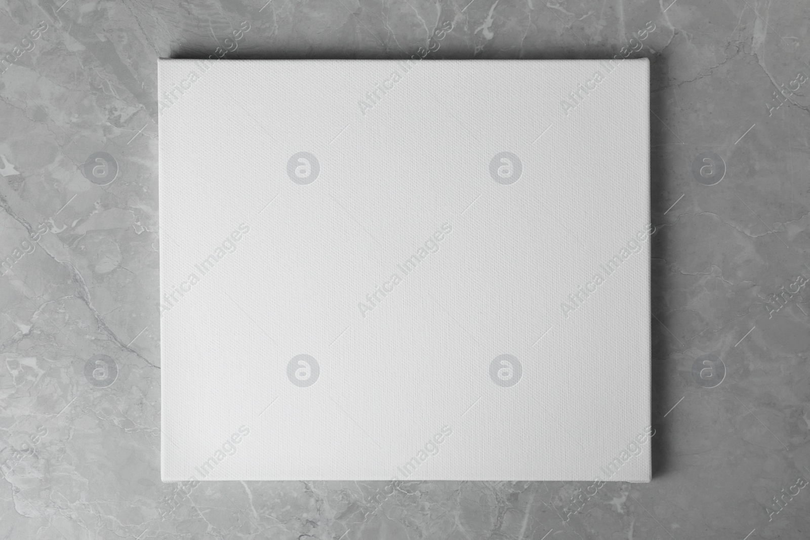 Photo of Blank canvas on grey marble table, top view. Space for text