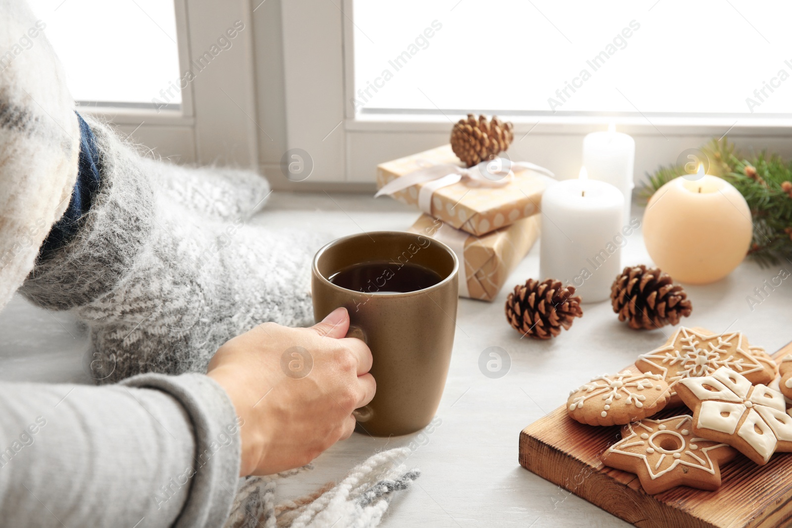 Photo of Woman relaxing with cup of hot winter drink near window. Cozy season