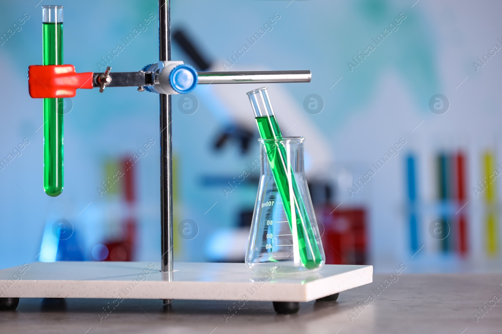 Photo of Laboratory glassware with green liquid on table indoors