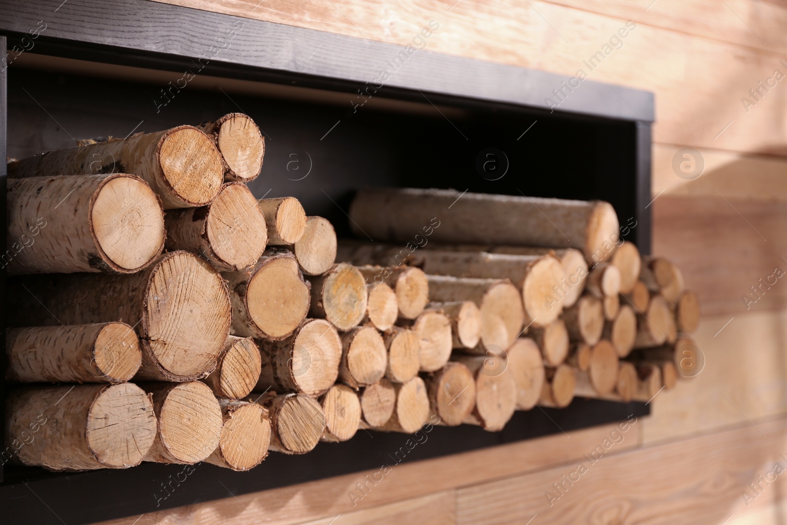 Photo of Decorative fireplace with stacked wood indoors. Idea for interior design