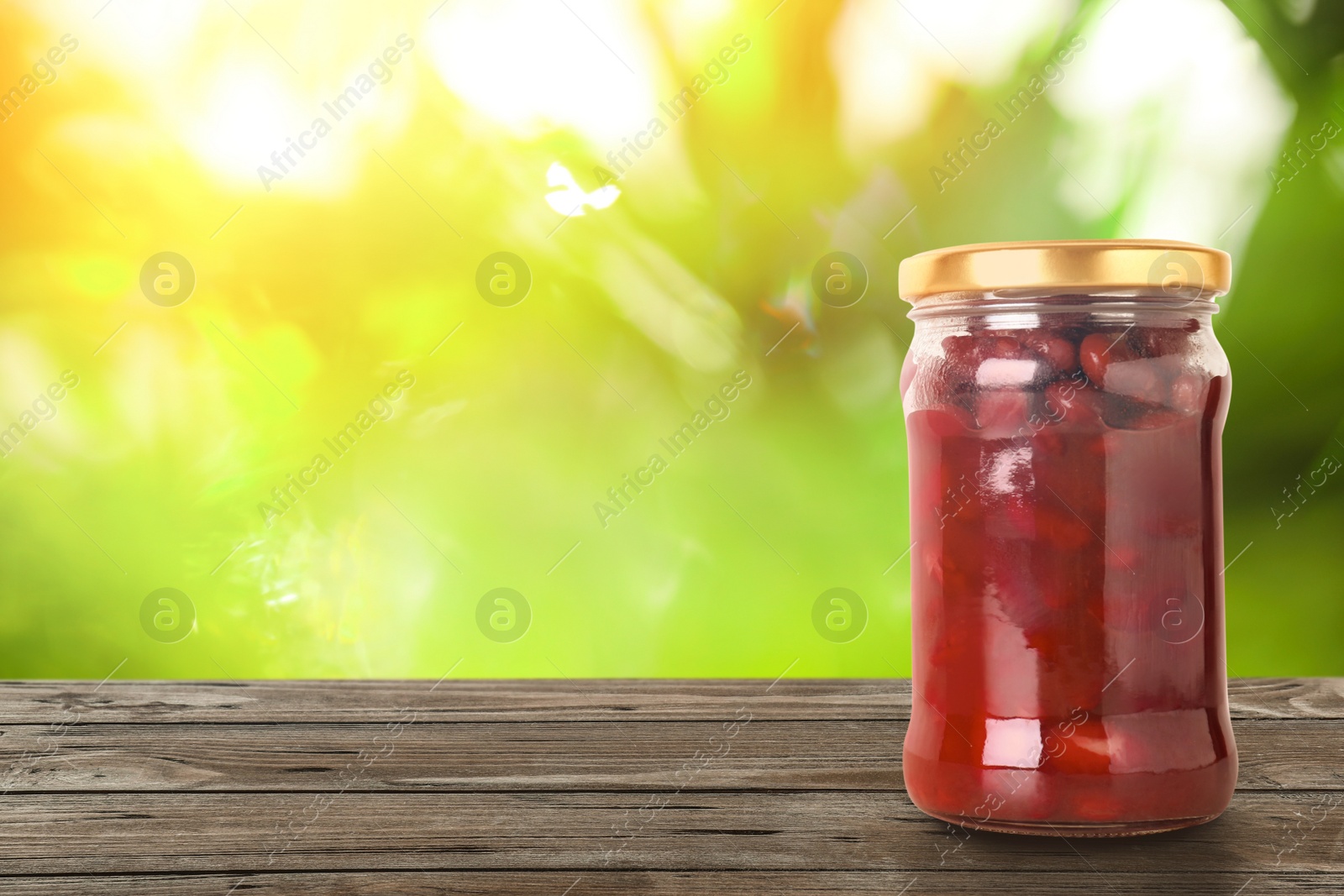 Image of Jar of pickled beans on wooden table against blurred background, space for text