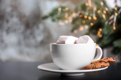 Photo of Cup of aromatic cacao with marshmallows and cookies on table, closeup. Space for text