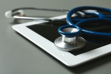 Photo of Stethoscope and tablet on table, closeup. Medical students stuff