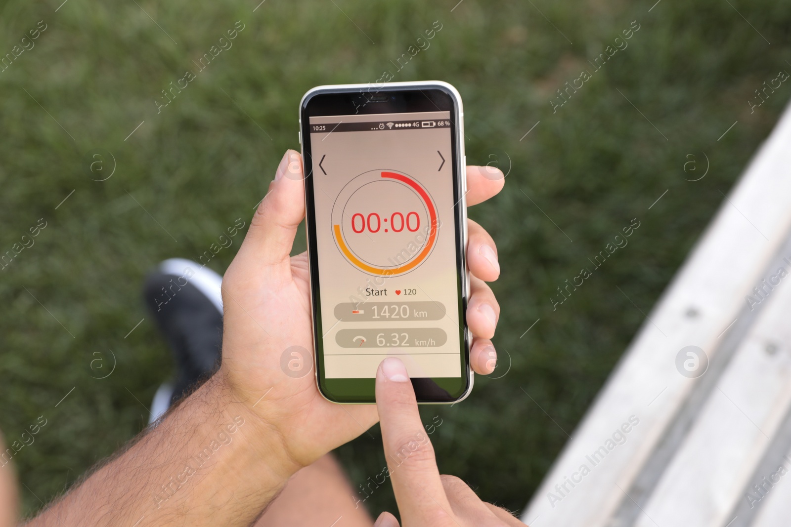 Photo of Man using fitness app on smartphone outdoors, top view