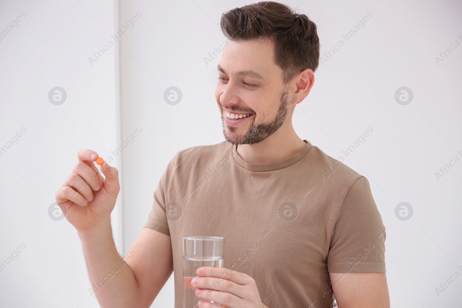 Photo of Young man taking vitamin indoors