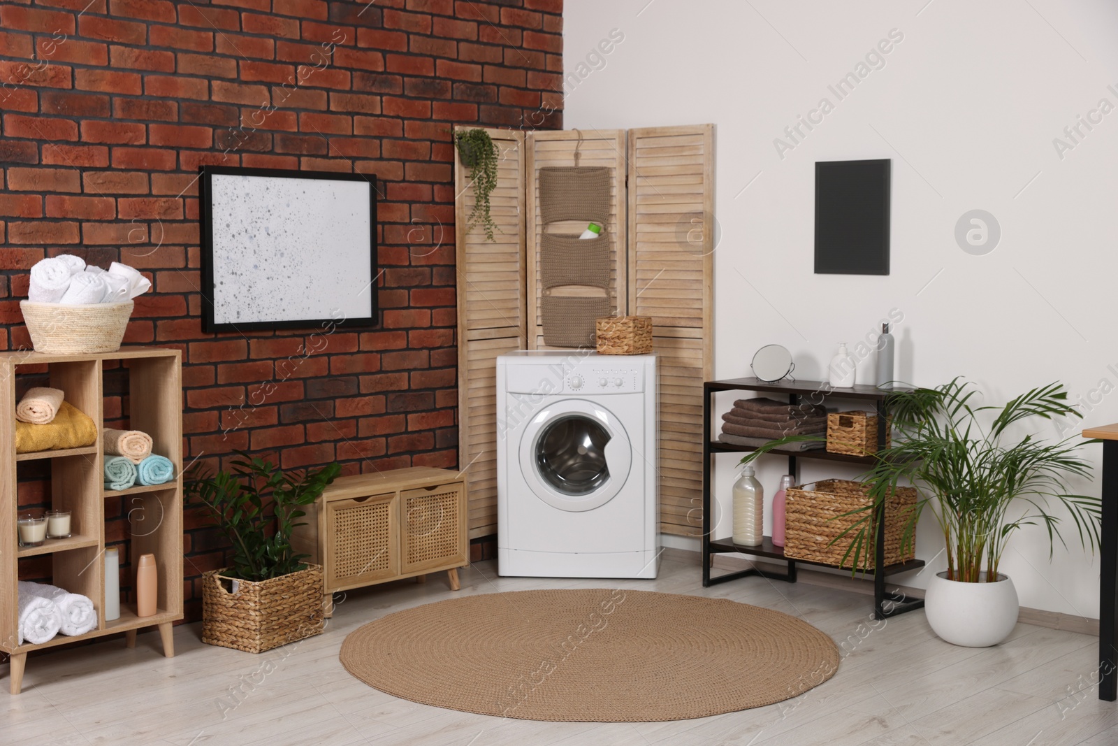 Photo of Stylish laundry room with washing machine. Interior design